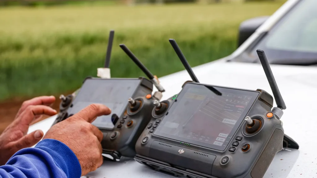 Profesionales agrícolas utilizando drones y tecnología de precisión en una explotación.