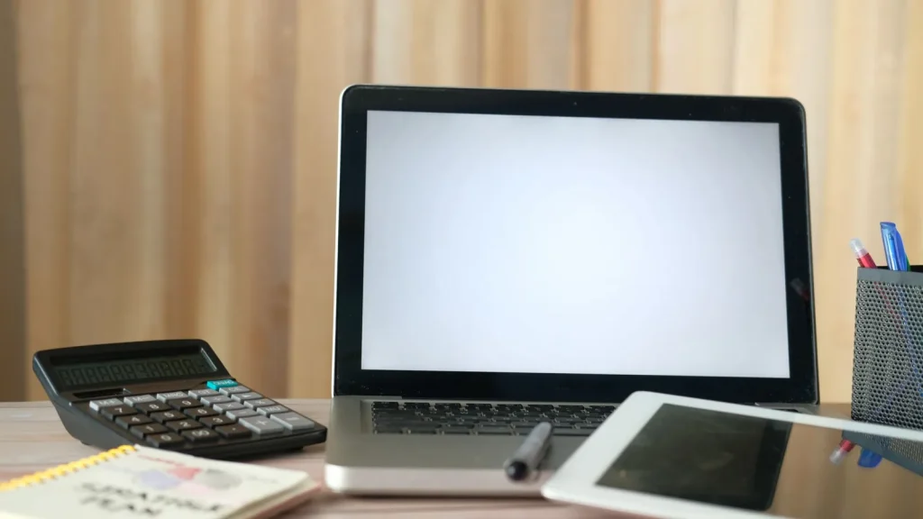 Portátil y calculadora en un escritorio de gestión empresarial