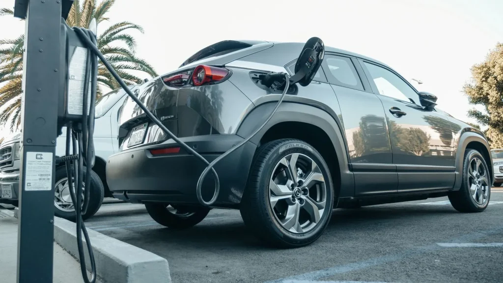 Vehículo eléctrico conectado a un punto de recarga, relacionado con las ayudas Auto+ para empresas y autónomos