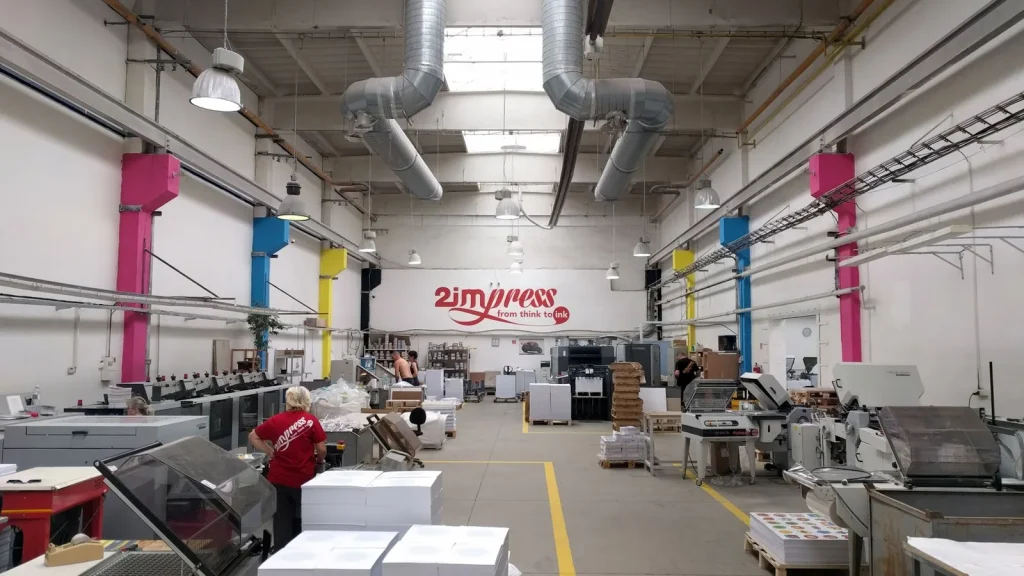 Trabajadores y maquinaria en una planta moderna de artes gráficas e impresión