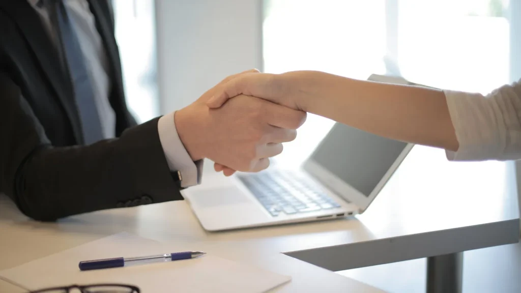 Empresa y candidato estrechando la mano durante un proceso de contratación.
