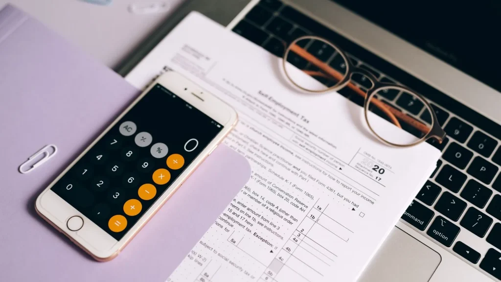 Autónoma revisando cuentas con una calculadora para planificar las cuotas de 2027.