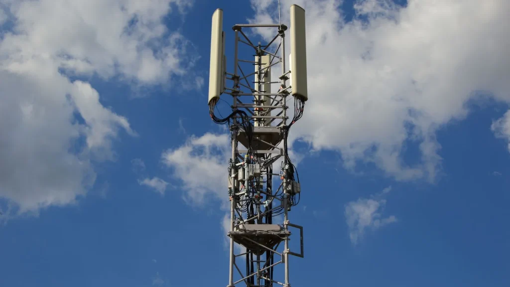 Antena 5G conectando instalaciones industriales y dispositivos empresariales.
