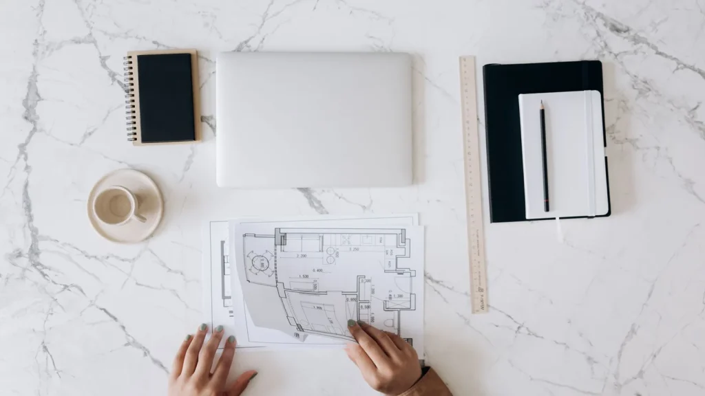 Mesa de arquitecto con planos, portátil y documentación de proyecto