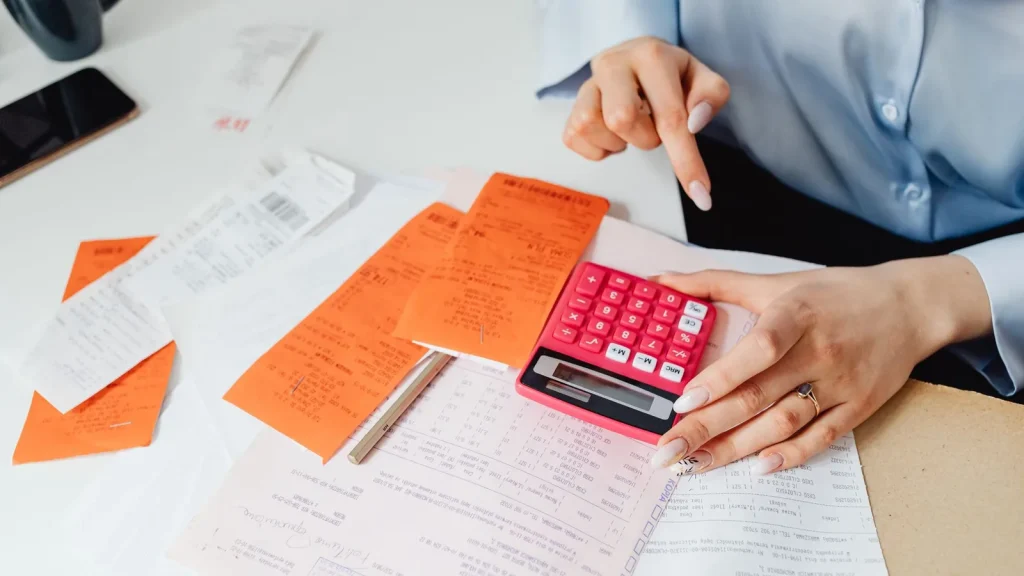 Recibos y calculadora utilizados para revisar gastos deducibles de una actividad autónoma
