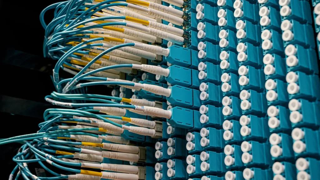 Infraestructura de fibra óptica y servidores para centros de datos de inteligencia artificial.