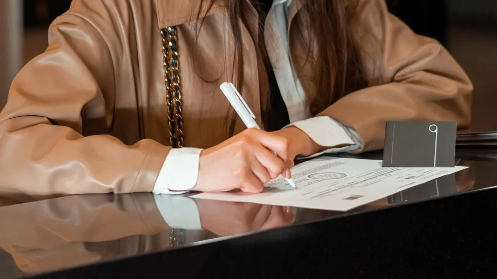 Persona firmando documentación empresarial, relacionada con la creación de nuevas sociedades mercantiles.