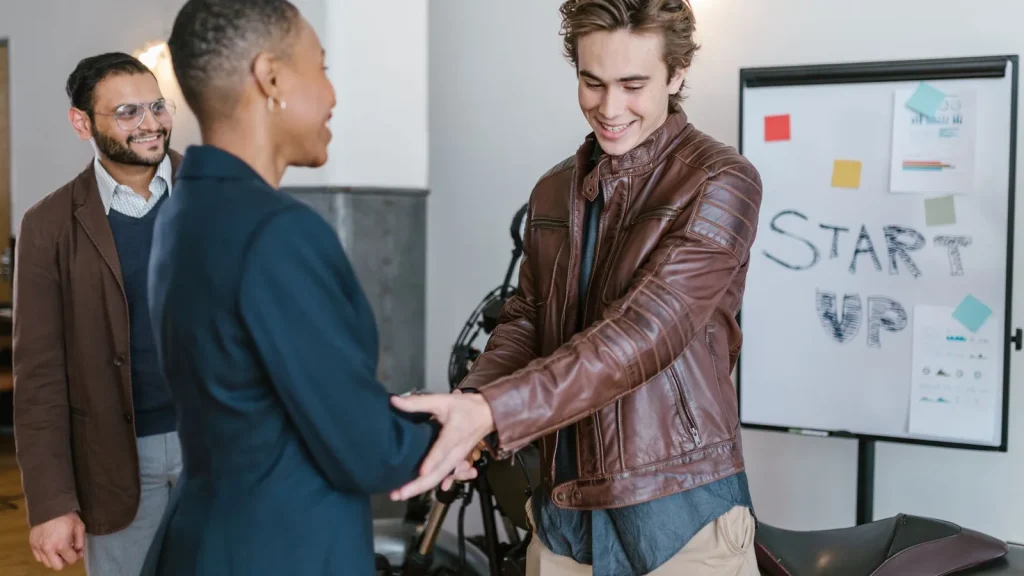 Emprendedores e inversores estrechando la mano durante una reunión de startups.