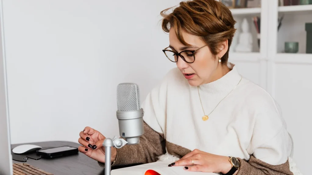 Narradora grabando un audiolibro en un estudio con micrófono